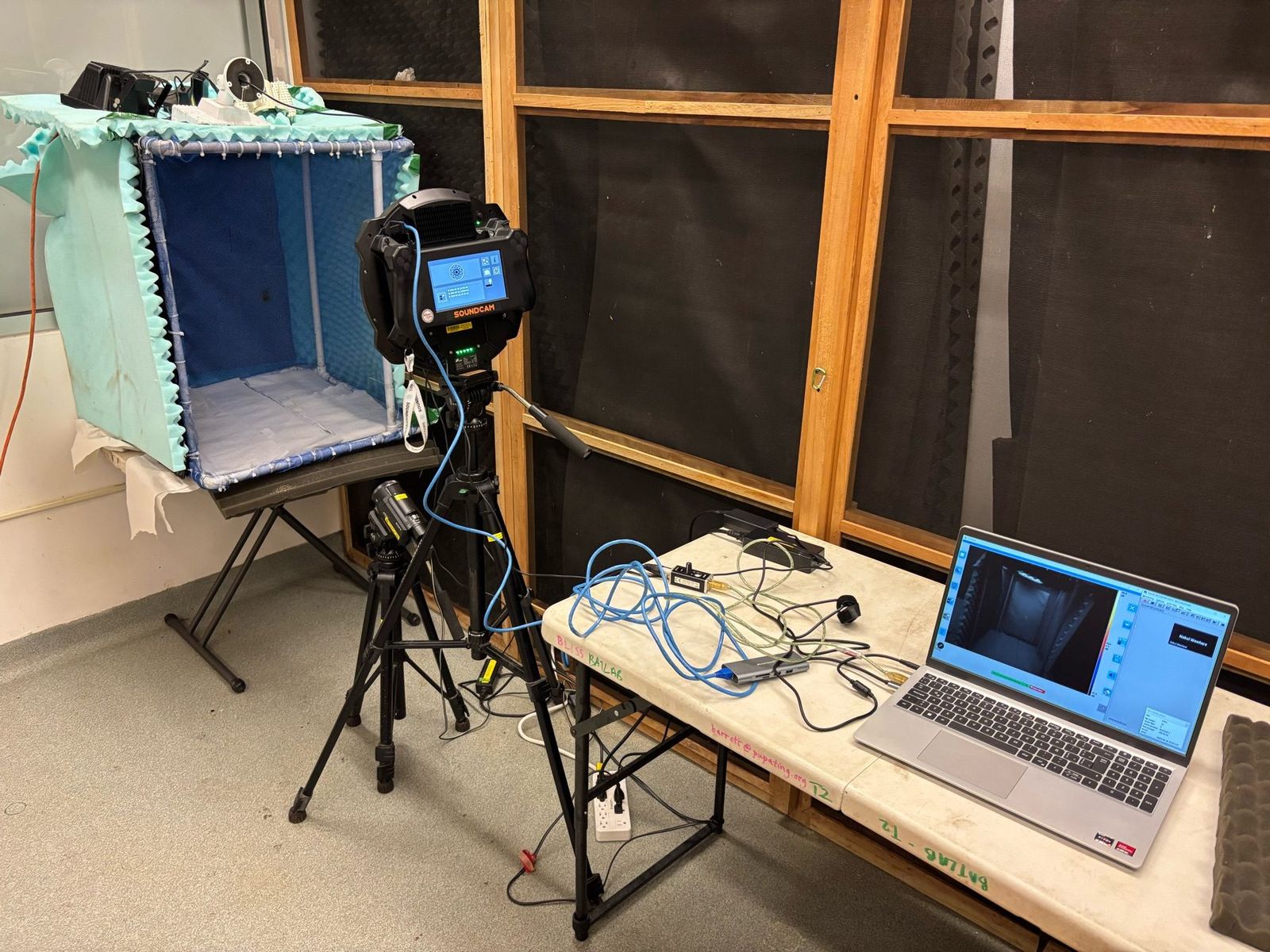 A sound camera faces a small recording enclosure beside two open laptops and connected cables in the Gamboa laboratory.