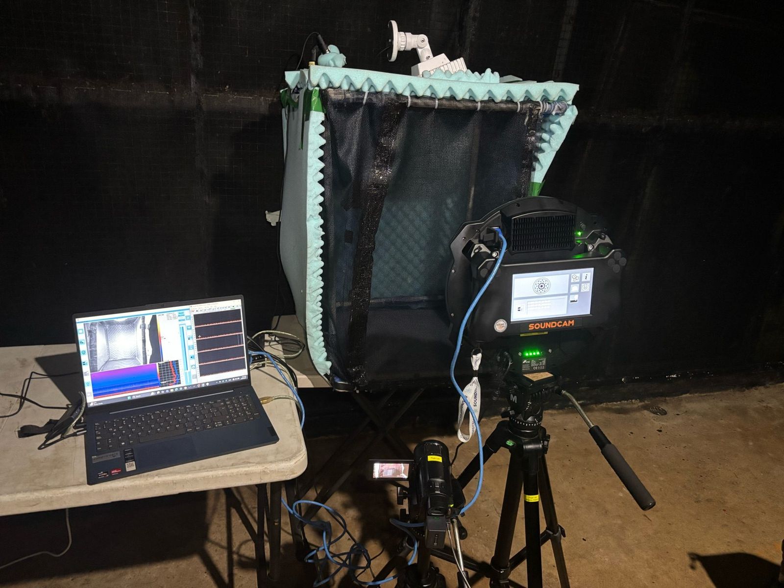 A sound camera, laptop, and recording enclosure are arranged for an outdoor vampire-bat recording session in Panama.