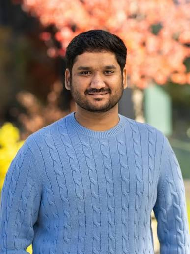 Portrait of Nakul Wewhare wearing a light-blue sweater outdoors.